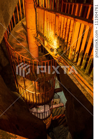 Spiral staircase in limestone cave 111904761