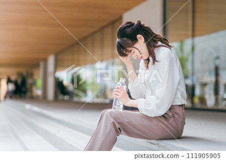 坐在商業區/商業設施中的女商人/職業母親看起來很沮喪 111905905