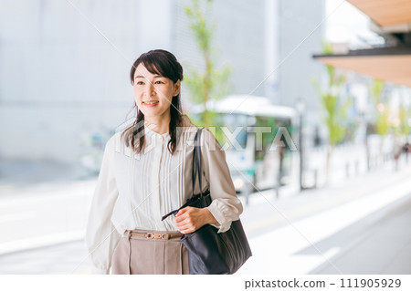 Business woman/working mother walking/going to work in an urban office district 111905929