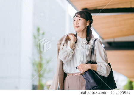 Business woman/working mother walking/going to work in an urban office district 111905932