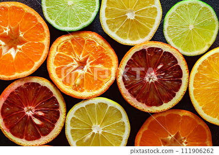 Citrus fruits cut in half, oranges, tangerines, yellow lemons, green limes, top view close-up 111906262