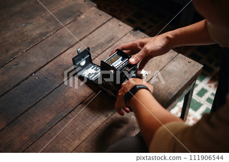 Closeup image of photographer swapping film in old camera Closeup image of photographer swapping film in old camera 111906544