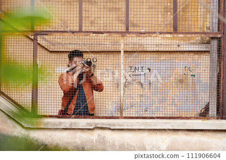 Journalist photographing abandoned buildings in old city area for news article Journalist photographing abandoned buildings in old city area for news article 111906604