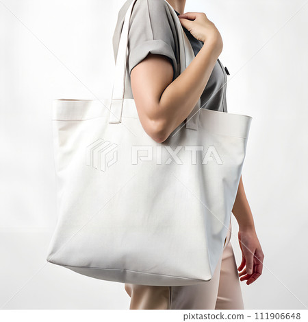 Woman holding reusable white cotton linen eco organic fabric canvas tote bag blank background for mockup 111906648