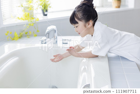 girl pouring hot water into the bath 111907711