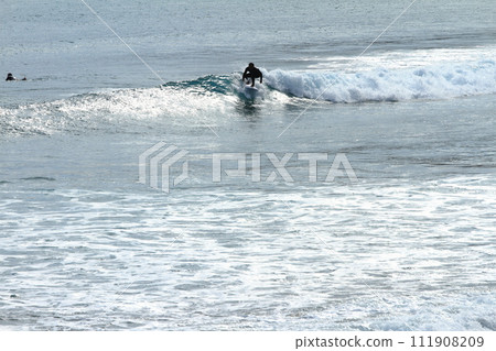 Surfer riding the big waves of Koigaura in Miyazaki 111908209