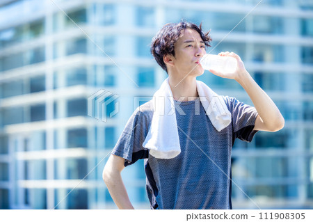 A scene where a man is hydrating in the gym A scene where a man is hydrating in the gym 111908305