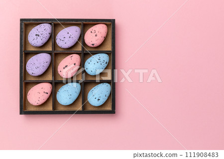 Colorful Easter eggs in a box on the pink background Colorful Easter eggs in a box on the pink background 111908483