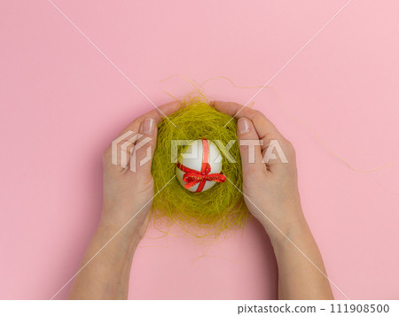 Easter egg with a red ribbon in a nest. Easter egg with a red ribbon in a nest. 111908500