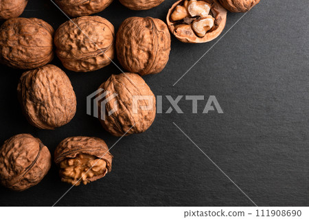 walnuts on black slate background 111908690