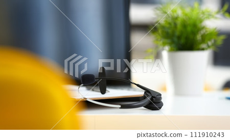 Empty remote office workplace with laptop and headset Empty remote office workplace with laptop and headset 111910243