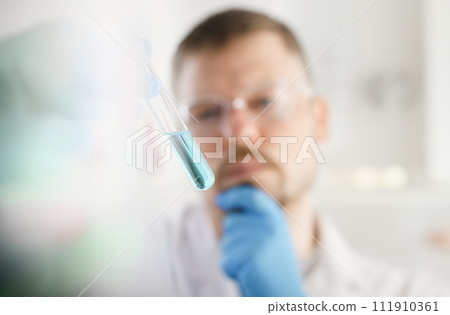 A male chemist holds test tube of glass A male chemist holds test tube of glass 111910361