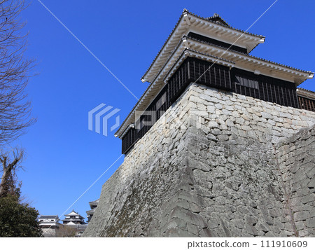 View of the large and small castle towers from beneath the drum turret of Matsuyama Castle. 111910609