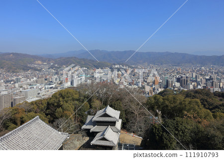 從松山城的城樓眺望愛媛大學、道後、石手。前景是天神角樓的屋頂、大門以及門東的角樓。 從松山城的城樓眺望愛媛大學、道後、石手。前景是天神角樓的屋頂、大門以及門東的角樓。 111910793