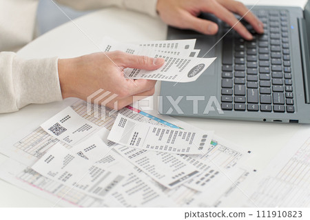 Hand of a man entering expenses into accounting software 111910823