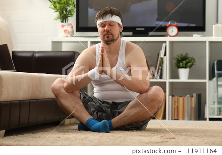 Young attractive fitness man lies on a fat mat with Young attractive fitness man lies on a fat mat with 111911164