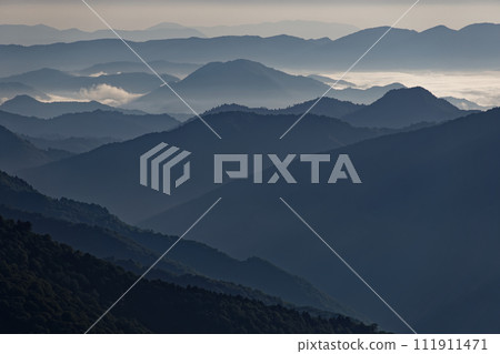 The mountain range in the morning mist seen from the climb to Mt. Hiugatake in Oze 111911471