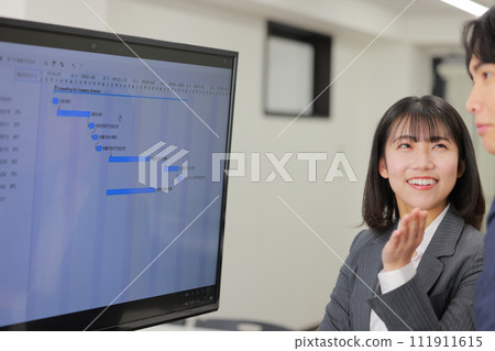 Business woman looking at the schedule and asking colleagues for opinions_1 111911615