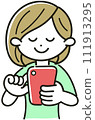 A young woman facing forward and operating a smartphone 111913295