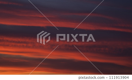 Dramatic sunset with vibrant clouds lit by a sun 111913904