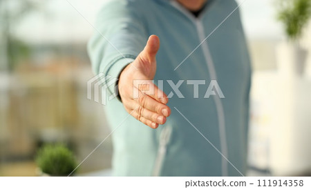 Man in suit and tie give hand as hello in office closeup 111914358