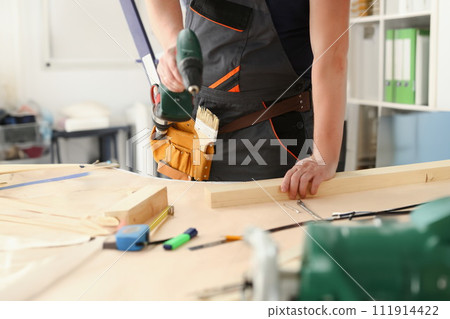 Arms of worker using electric drill Arms of worker using electric drill 111914422