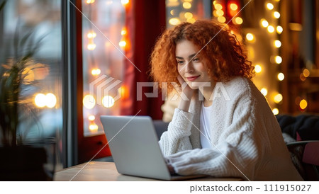Redhead woman using laptop in a cozy cafe 111915027