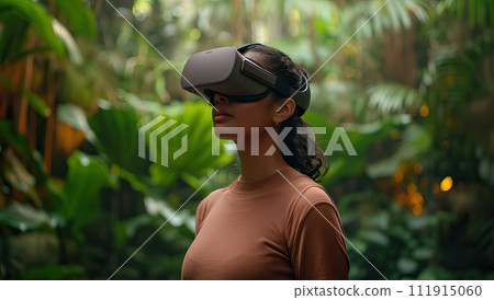 African American woman experiencing virtual reality in tropical forest 111915060