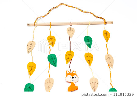Felt leaf garland, a vibrant burst of multicolored foliage adorning a dark brown wall, adding warmth and autumnal charm to any space Felt leaf garland, a vibrant burst of multicolored foliage adorning a dark brown wall, adding warmth and autumnal charm to any space 111915329