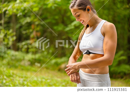 Well trained woman using fitness smart watch device under workout Well trained woman using fitness smart watch device under workout 111915381