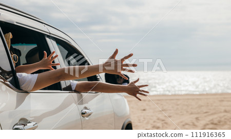 Close up hands. Happy family sitting in car waving hands travel outside car windows on beach travel, Father, mother and children raise hand wave goodbye, People fun outdoor road trip, vacation holiday Close up hands. Happy family sitting in car waving hands travel outside car windows on beach travel, Father, mother and children raise hand wave goodbye, People fun outdoor road trip, vacation holiday 111916365