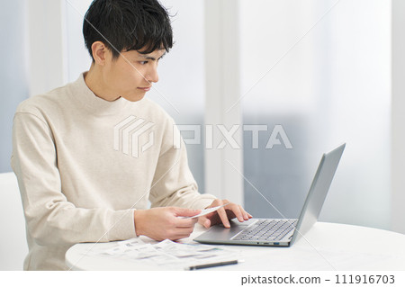 一名男子將費用輸入會計軟體 一名男子將費用輸入會計軟體 111916703