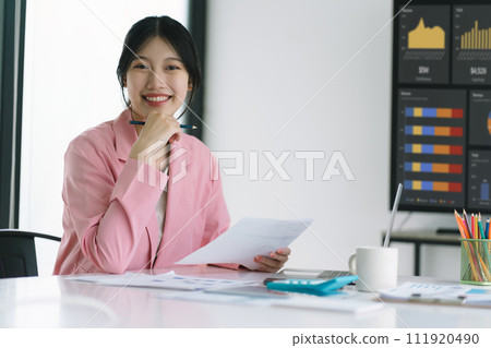 Millennial Asian businesswoman working with financial reports for a tax audit reports or financial statement in the company. 111920490