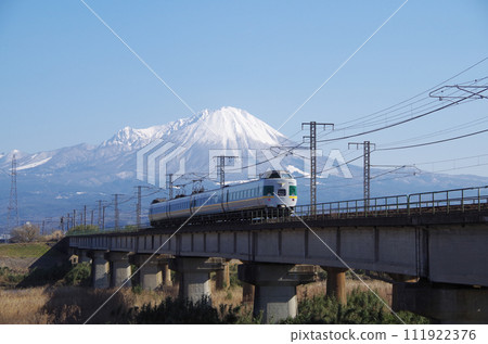 翻版的綠色381系列特急八雲號行駛在日野川的鐵路長橋上，背景是白雪皚皚的富士山。 111922376