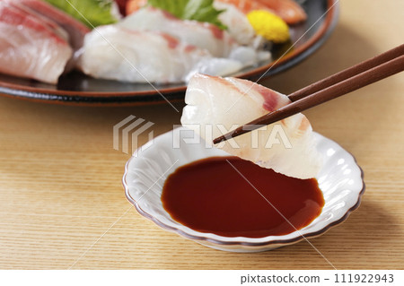 用筷子夾起看起來很美味的鯛魚生魚片 111922943