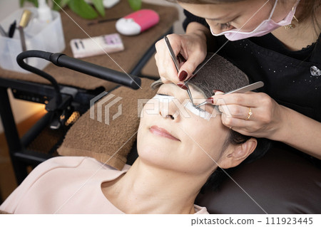 A woman receiving eyelash extensions (photography cooperation: Makanani) A woman receiving eyelash extensions (photography cooperation: Makanani) 111923445