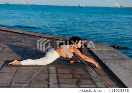 Woman doing yoga asana breathing practice on the beach by the sea Woman doing yoga asana breathing practice on the beach by the sea 111923578