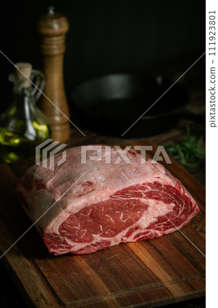 chunk of ribeye steak on wooden board chunk of ribeye steak on wooden board 111923801