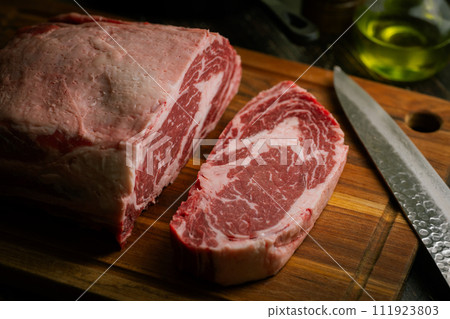 chunk of ribeye steak on wooden board chunk of ribeye steak on wooden board 111923803