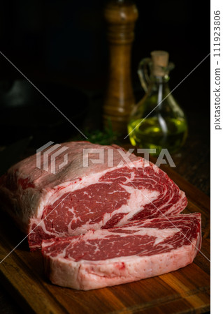 chunk of ribeye steak on wooden board chunk of ribeye steak on wooden board 111923806