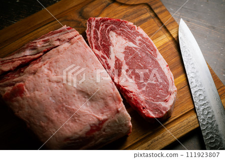 chunk of ribeye steak on wooden board chunk of ribeye steak on wooden board 111923807