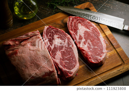 chunk of ribeye steak on wooden board 111923808