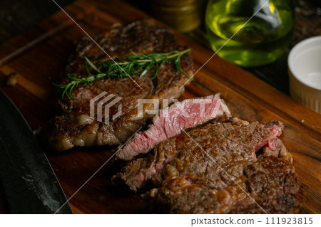 sliced ribeye steak on wooden board 111923815