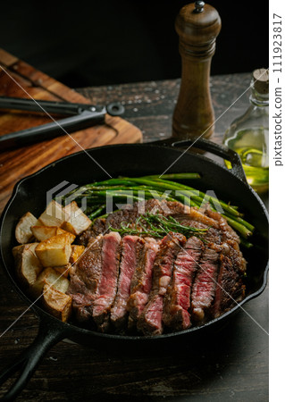 sliced ribeye steak in iron cast skillet pan sliced ribeye steak in iron cast skillet pan 111923817