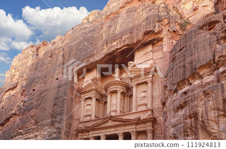 Al Khazneh or The Treasury (against the background of a beautiful sky with clouds). Petra, Jordan-- it is a symbol of Jordan, as well as Jordan's most-visited tourist attraction Al Khazneh or The Treasury (against the background of a beautiful sky with clouds). Petra, Jordan-- it is a symbol of Jordan, as well as Jordan's most-visited tourist attraction 111924813
