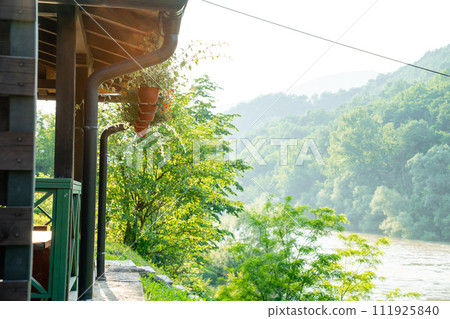 Porch of a wooden house in the forest on the river bank 111925840