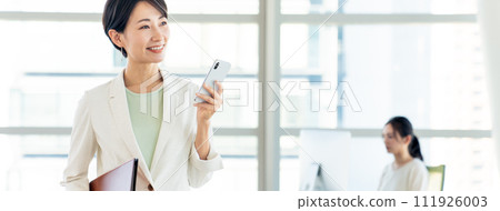 有一部智能手機的女商人在辦公室 111926003