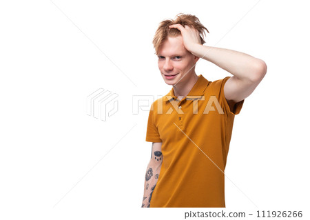 portrait of handsome young redhead caucasian male student with tattoo dressed in mustard t-shirt 111926266