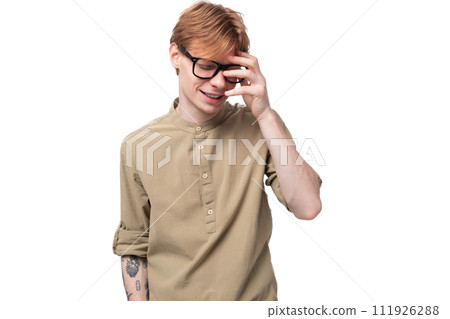 young slender red-haired European man dressed in a light brown shirt with a tattoo 111926288