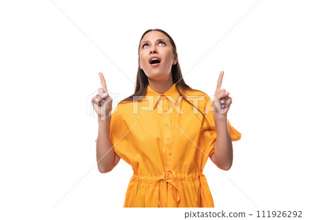 well-groomed slender young brunette lady is dressed in a bright yellow dress with short sleeves well-groomed slender young brunette lady is dressed in a bright yellow dress with short sleeves 111926292